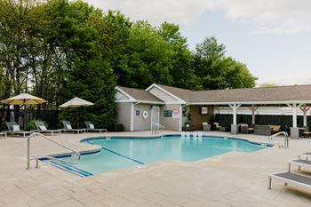 A pool with a slide and a building behind it.